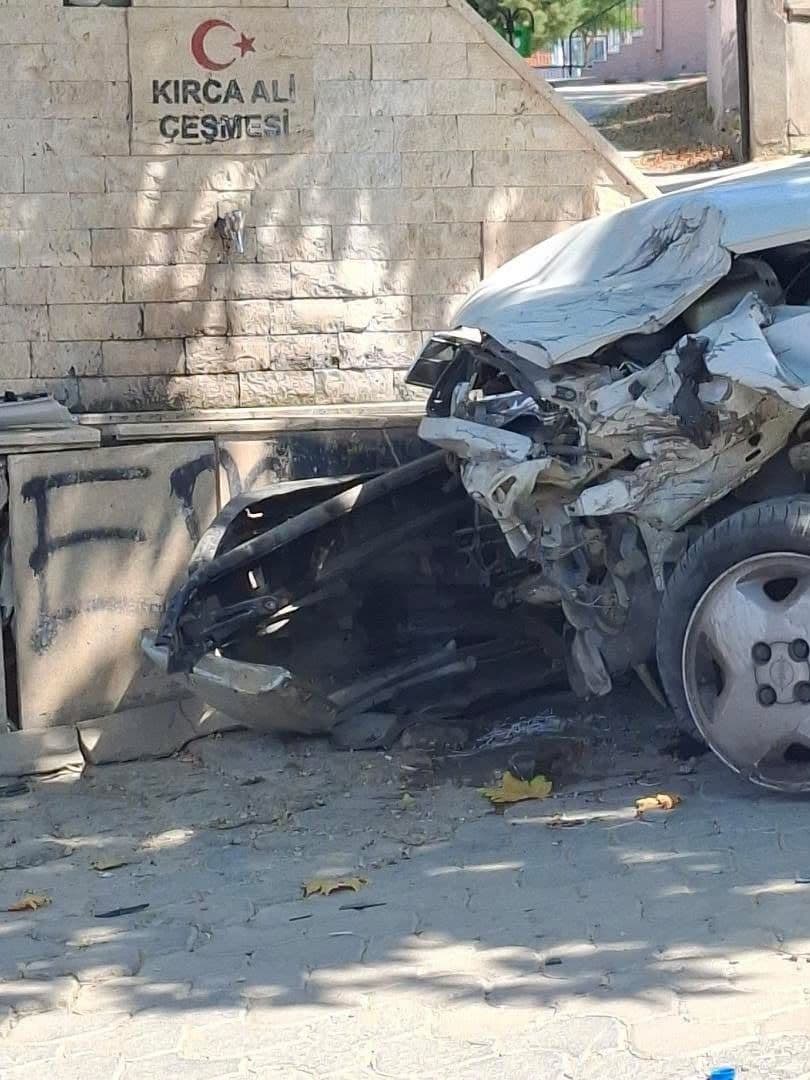 Erdek'te kazaya karışan, ön kısmı hasarlı beyaz otomobil ve Kırca Ali Çeşmesi.