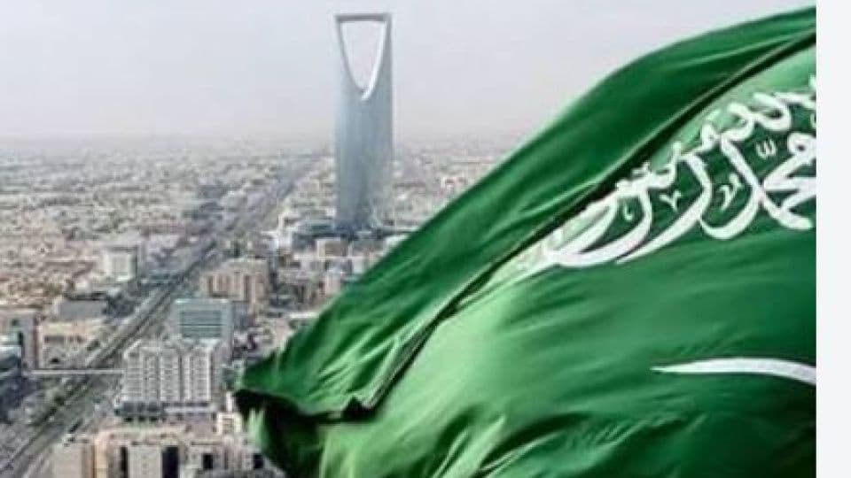 Suudi Arabistan bayrağı ve Riyad şehrinin silüeti.