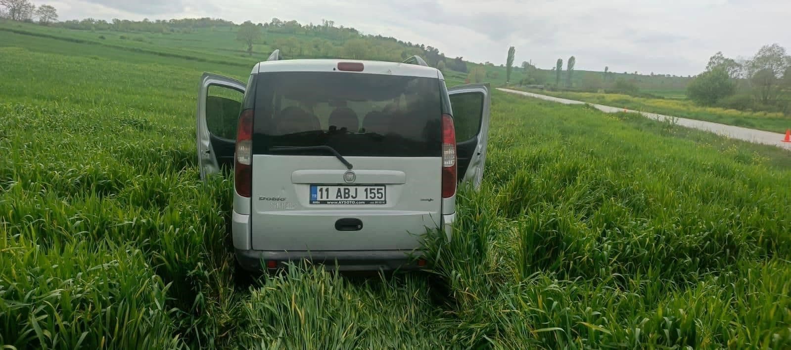Bilecik'te trafik kazası sonrası yol kenarındaki tarlada duran hasarlı otomobil.
