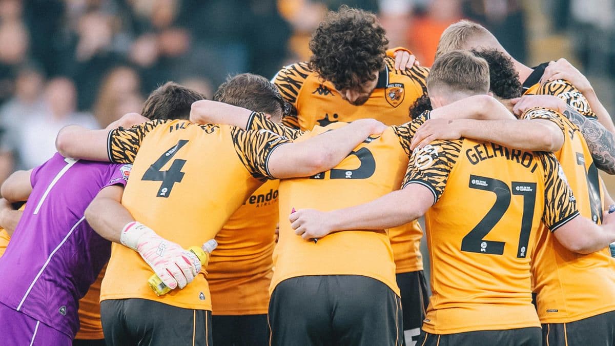 Hull City futbolcuları maç sırasında sahada bir araya gelmiş, takım ruhu sergiliyor.