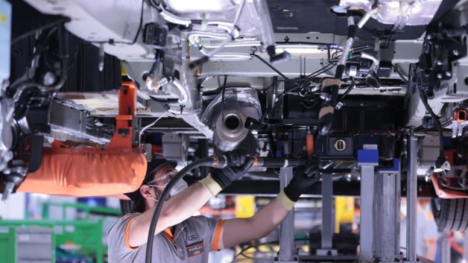 Avrupa'da şarj istasyonunda duran modern elektrikli otomobiller ve yükselen satış grafikleri.