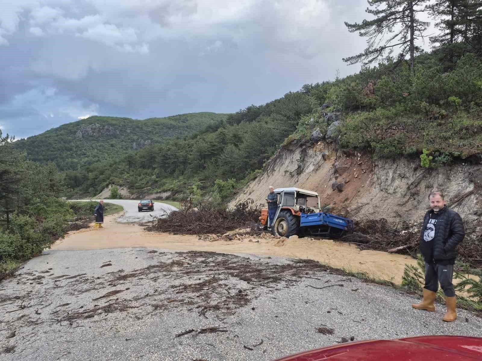 Bilecik'te sel ve heyelan sonrası çamurla kaplanan yolda mahsur kalmış bir traktör ve çevredeki vatandaşlar.