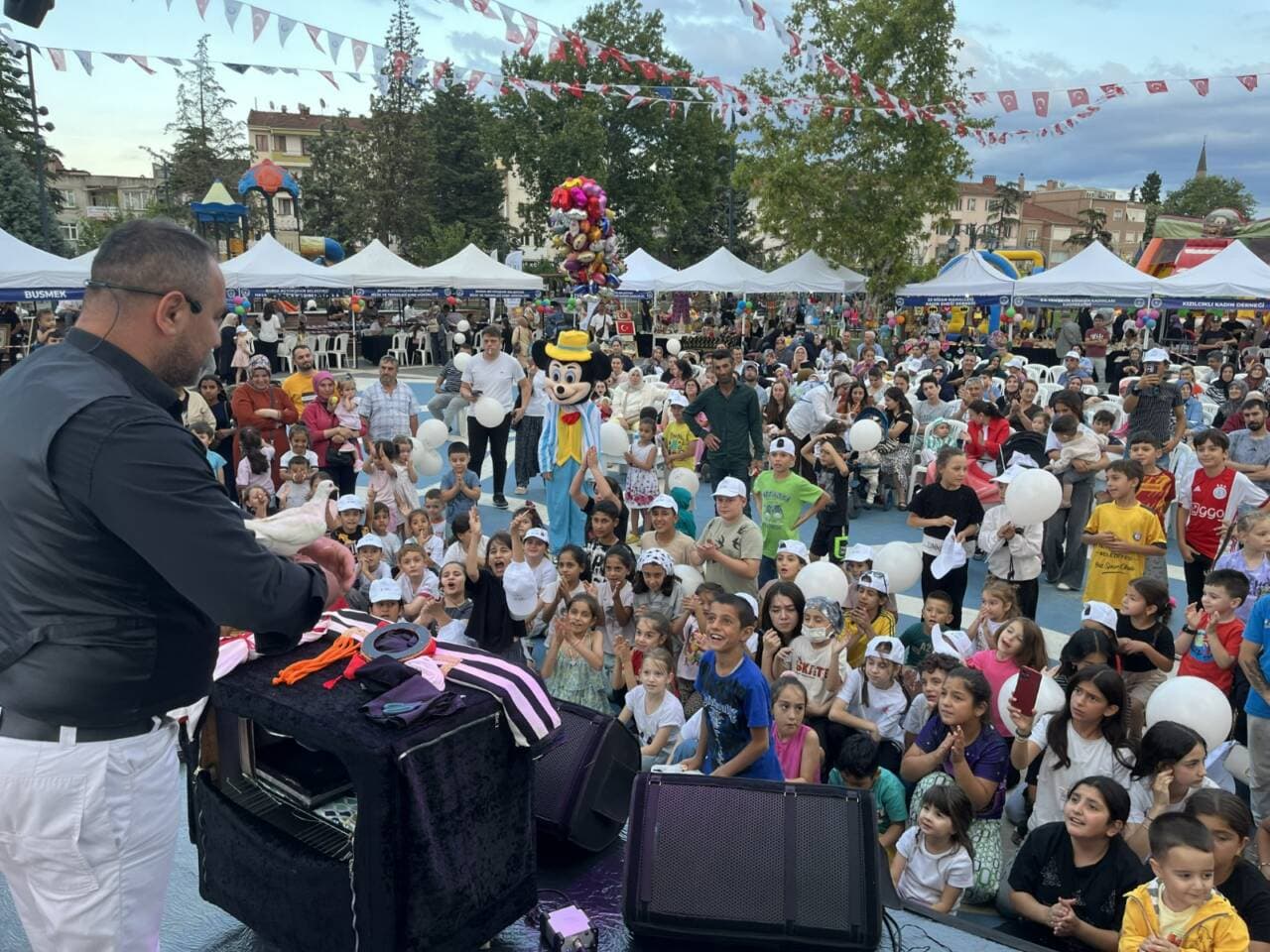 Bursa'nın Yenişehir ilçesinde düzenlenen fetih şenliklerinde sihirbaz gösterisi izleyen çocuklar ve kalabalık.