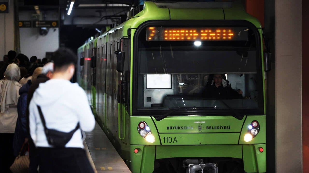 Bursa'da bir metro istasyonunda bekleyen yolcular ve istasyona yanaşan Bursaray treni.