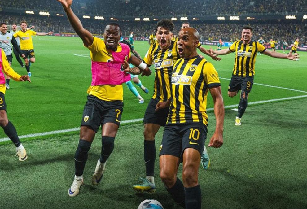 AEK Atina futbolcuları şampiyonluk sevinci yaşıyor, sahada kutlama yapıyorlar.