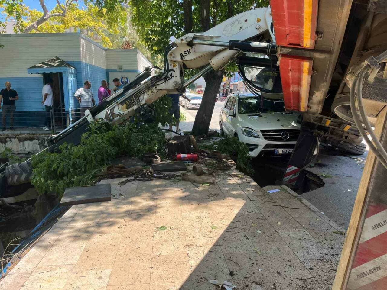 Bursa Mudanya'da dere temizliği sırasında devrilen vinç, hasarlı otomobil ve kaza alanı.