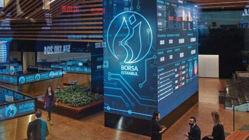 Borsa İstanbul binası içinde finansal verileri gösteren ekranlar ve çalışanlar.