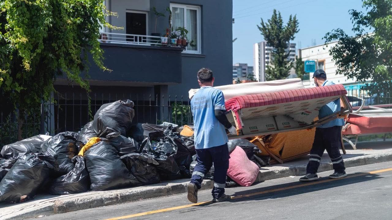 Bursa Yenişehir'de çöp evden çıkarılan atıkları taşıyan belediye temizlik görevlileri.