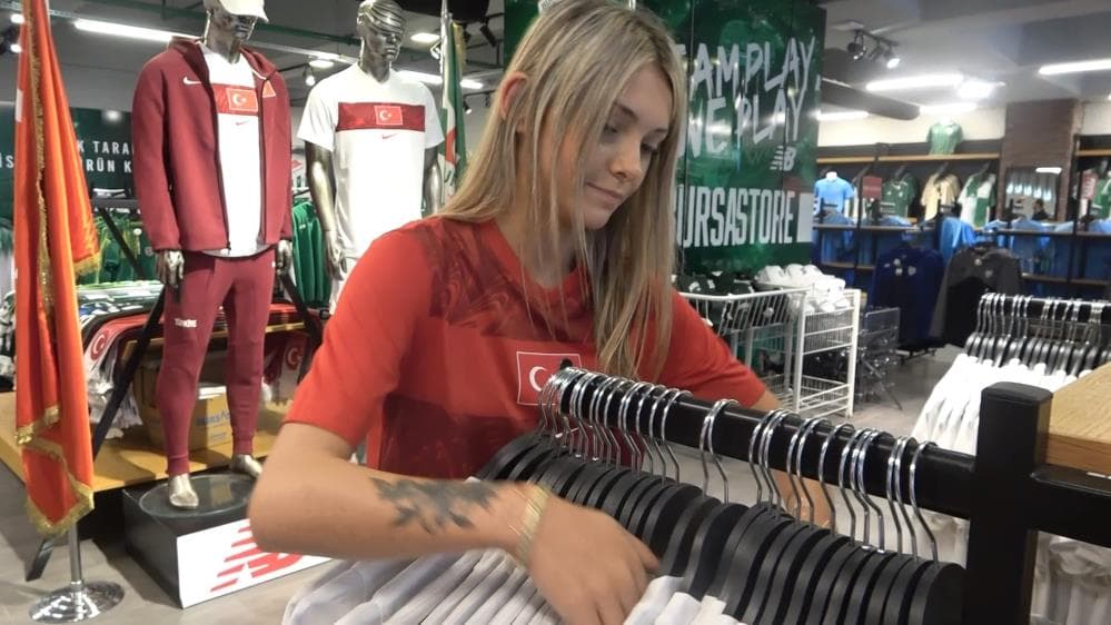 Bursastore'da milli takım formalarını düzenleyen bir mağaza çalışanı