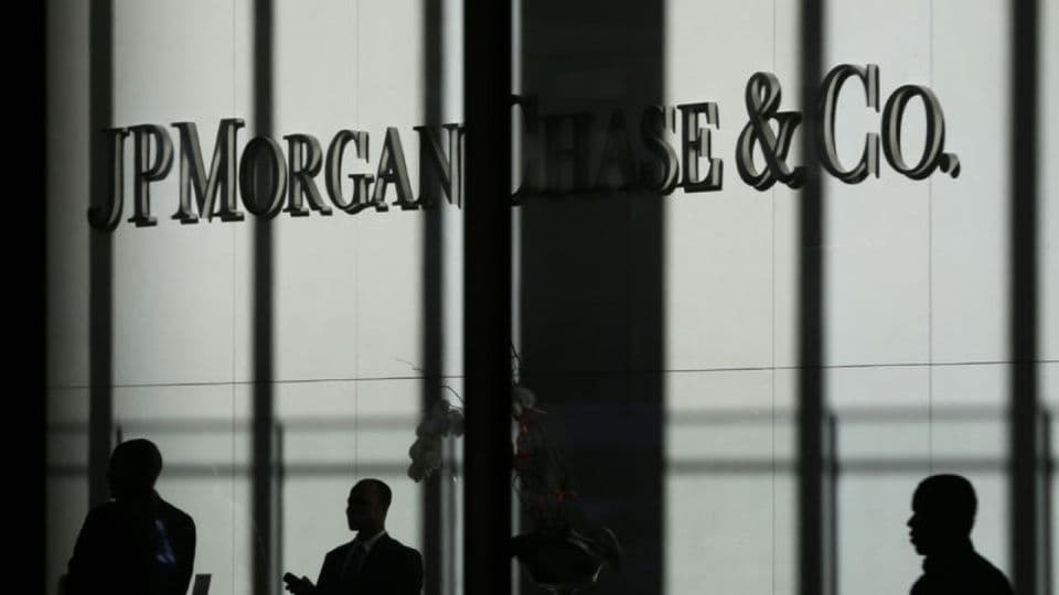 JPMorgan Chase & Co. logosu ve binasının önünden geçen insanların silüetleri.