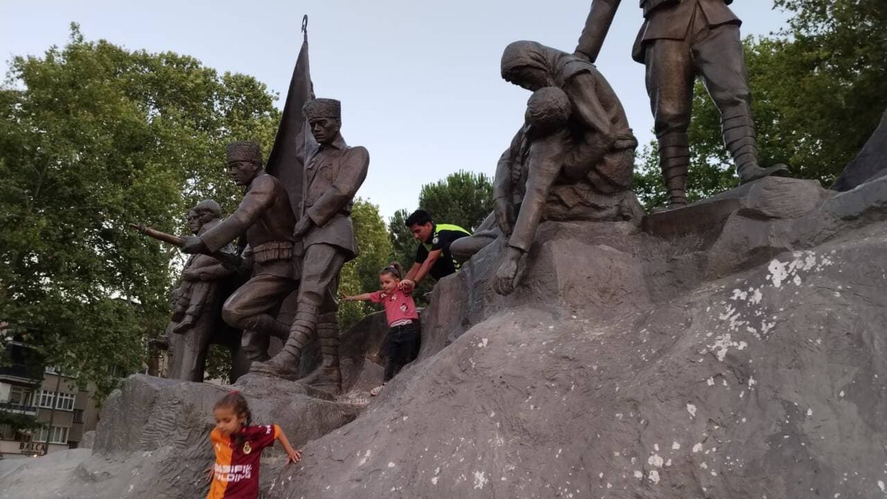 Bursa'da Atatürk heykeli üzerinde mahsur kalan çocuğu kurtaran polis memuru.