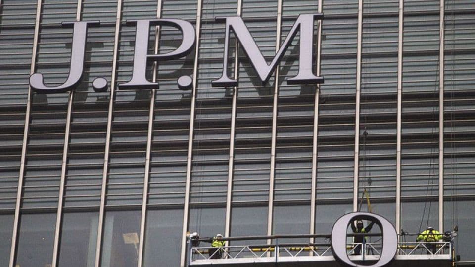 JPMorgan Chase binasının logosu ve önünde çalışan işçiler.