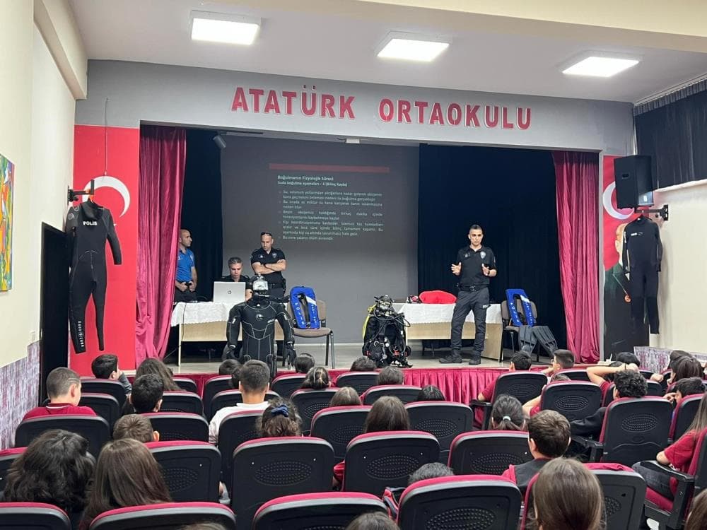Bursa Emniyeti'nden öğrencilere su güvenliği eğitimi veren polis memurları ve dinleyen öğrenciler.