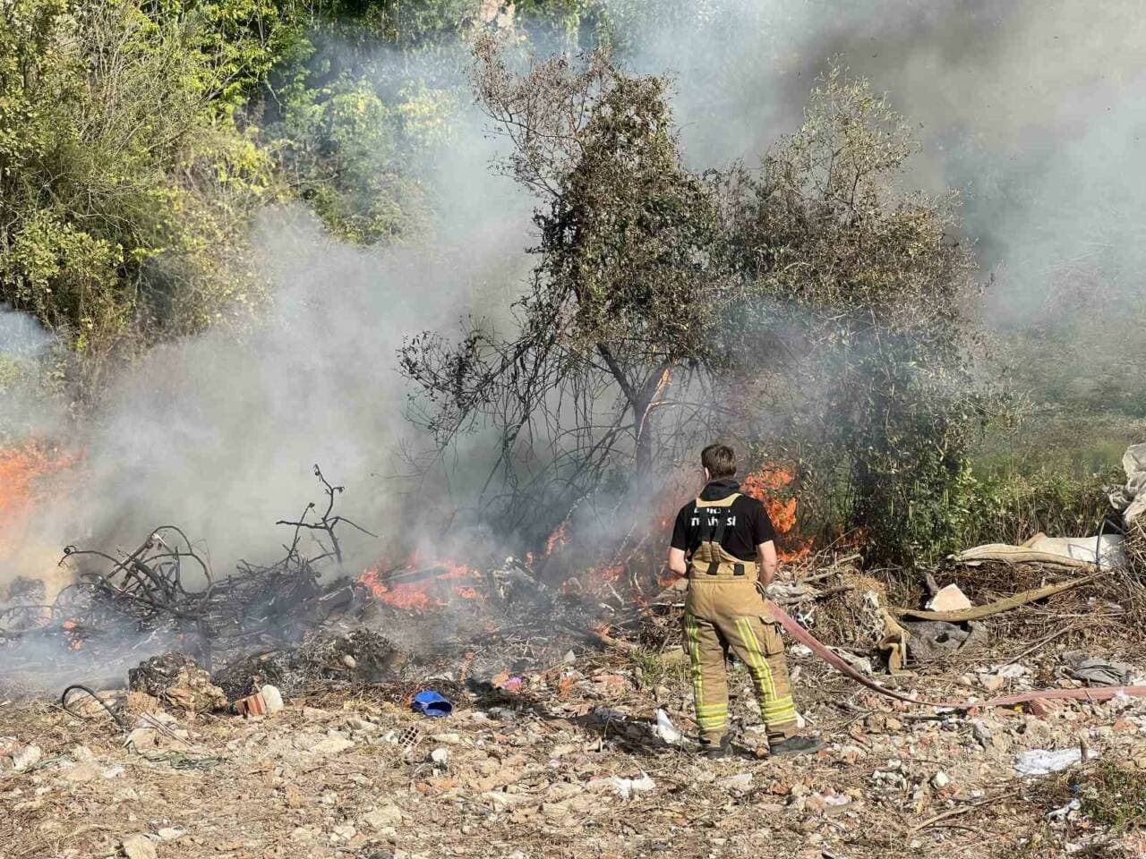 Mudanya'da orman yangınına müdahale eden itfaiyeci ve dumanlar.