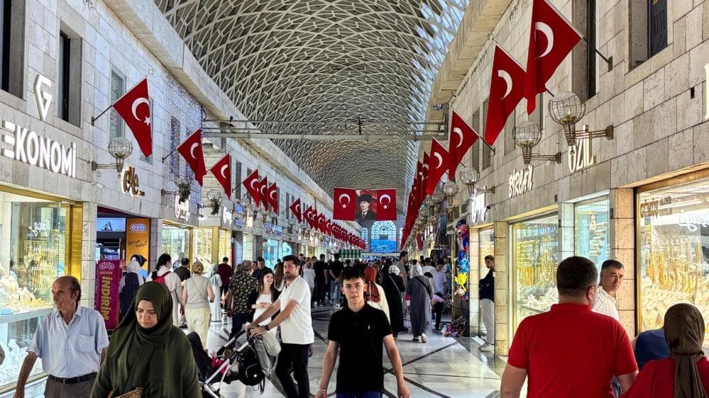 Bursa Kapalı Çarşı'da 30 Ağustos Zafer Bayramı için asılan Türk bayrakları ve çarşıda dolaşan insanlar.