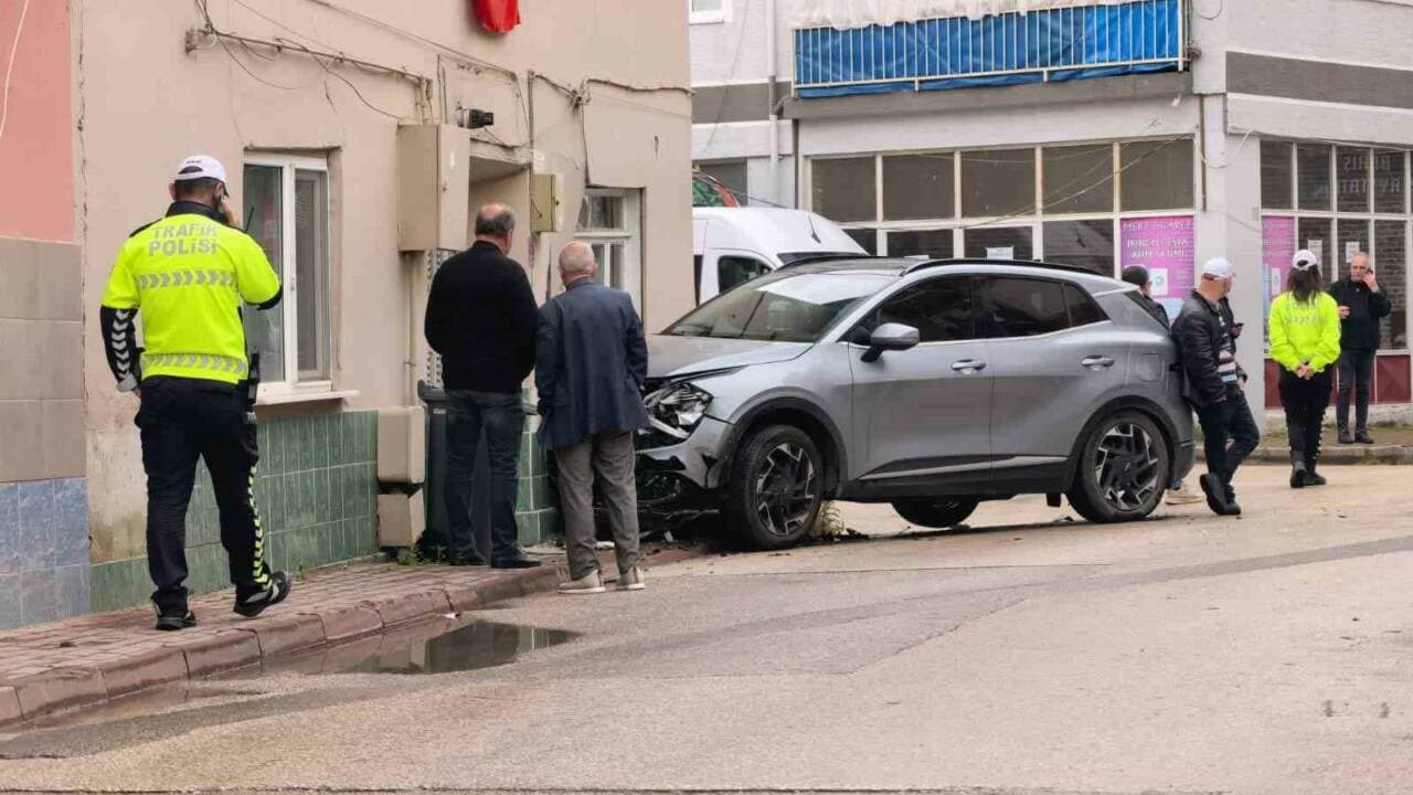 Bursa'da bir eve çarpmış hasarlı cip ve kaza yerinde inceleme yapan trafik polisi.