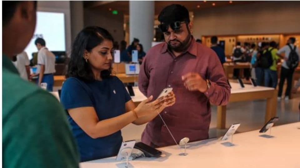Hindistan'da bir Apple mağazasında iPhone'ları inceleyen müşteriler.