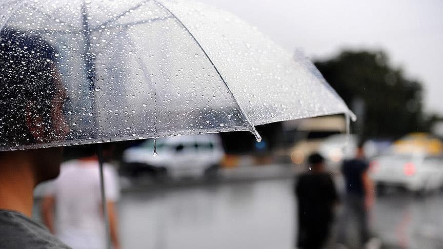 Bursa'da beklenen sağanak yağışı gösteren, yağmur damlalarıyla kaplı şeffaf bir şemsiye.