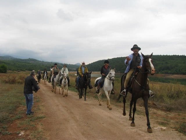 Evliya Çelebi Yolu'nda atlı bir grup, kameraman tarafından çekilirken doğal bir manzarada toprak yolda ilerliyor.