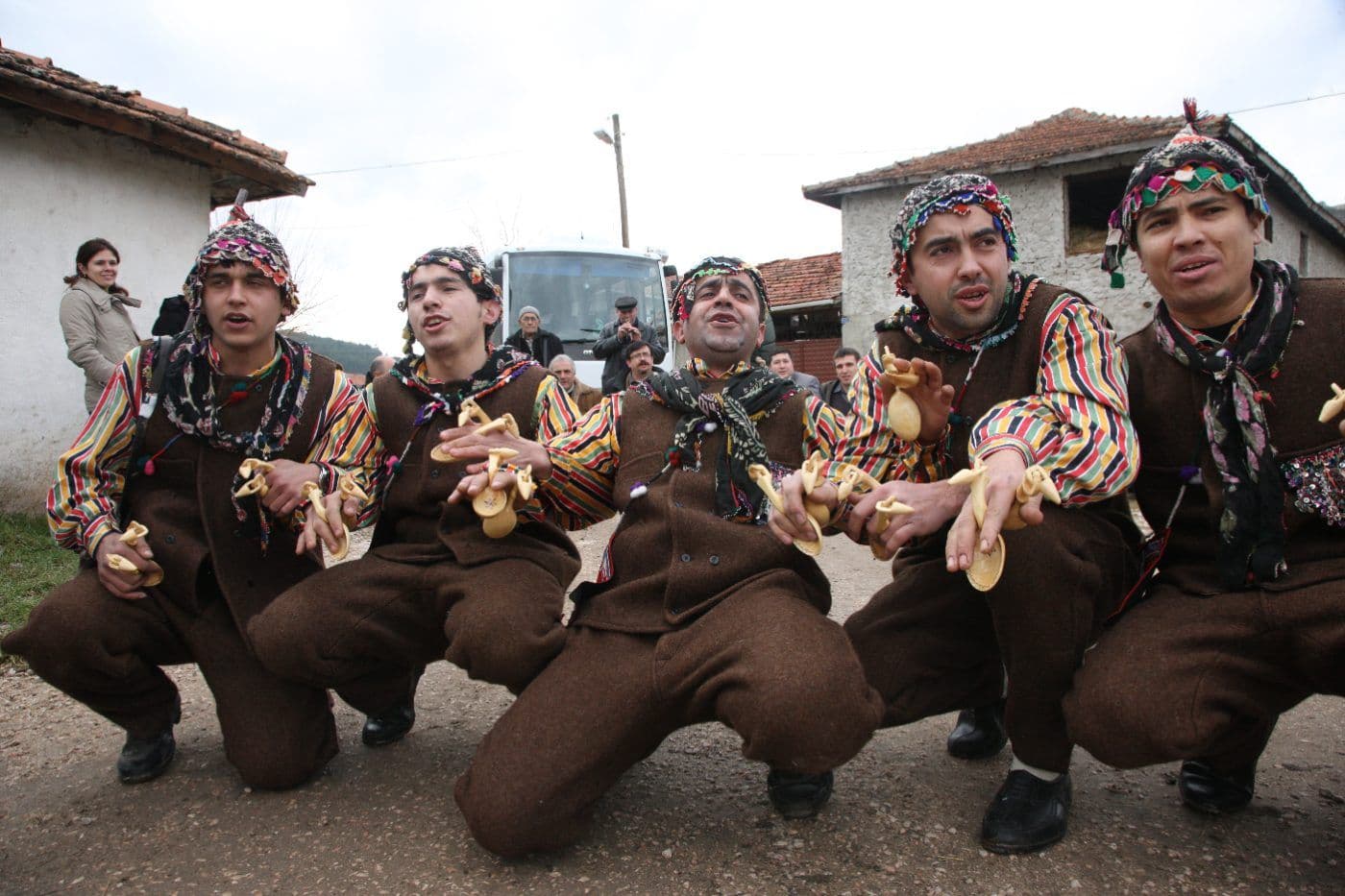 Bursa'da geleneksel kıyafetler giymiş, kaşıklarla halk oyunu oynayan beş erkek.