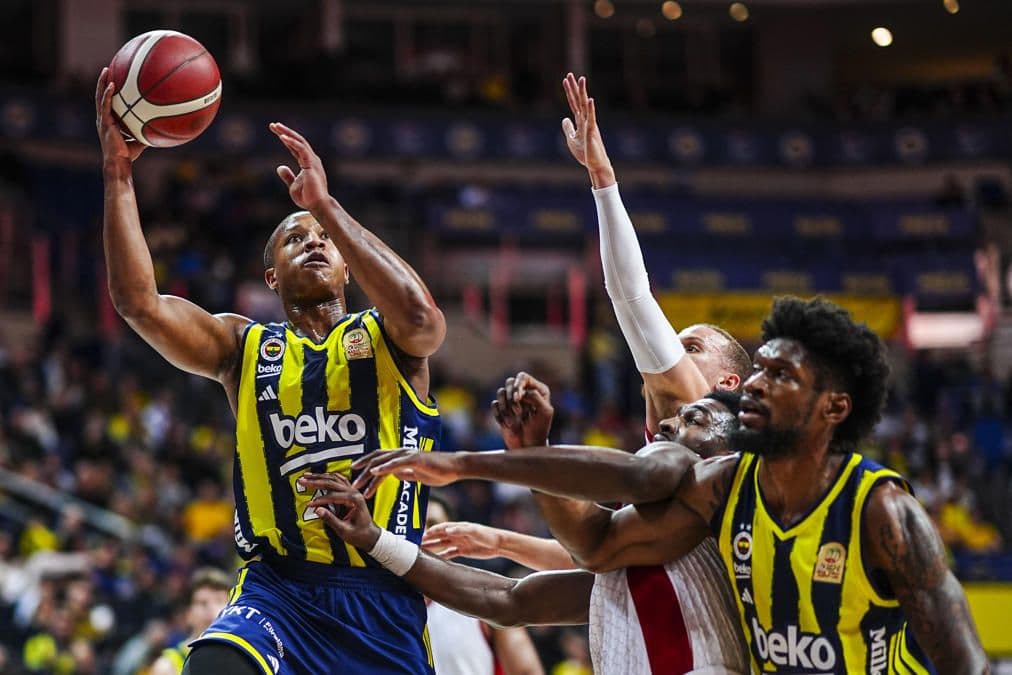 Fenerbahçe Beko basketbol takımı oyuncuları bir maç sırasında potaya atış yaparken.