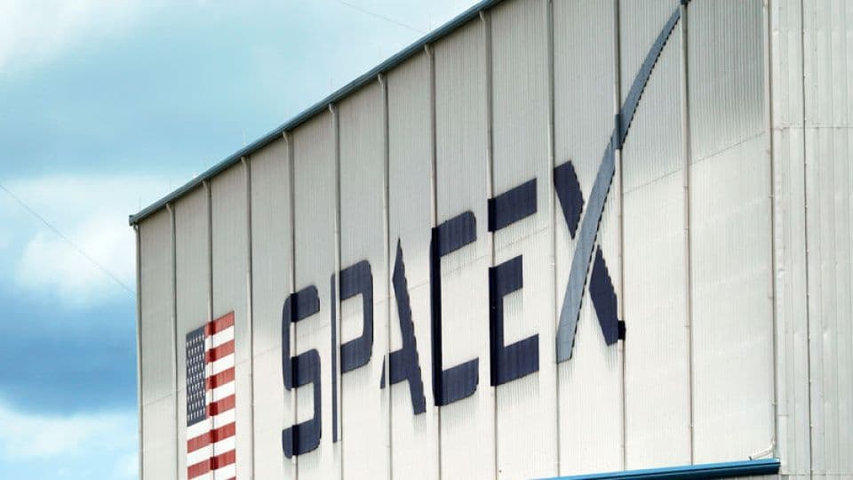 SpaceX logosunun ve Amerikan bayrağının bulunduğu bir bina.