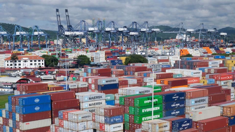 Limanda yükleme bekleyen konteynerler ve vinçler, küresel ticaret ve ihracat faaliyetleri.