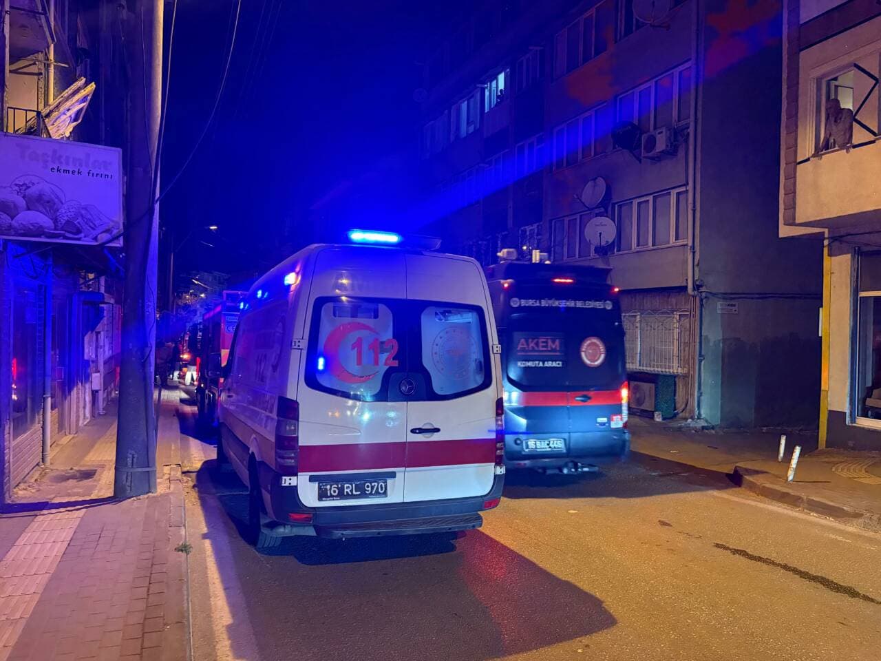Bursa Osmangazi'de yangın çıkan sokakta itfaiye ve ambulans ekipleri, gece vakti.
